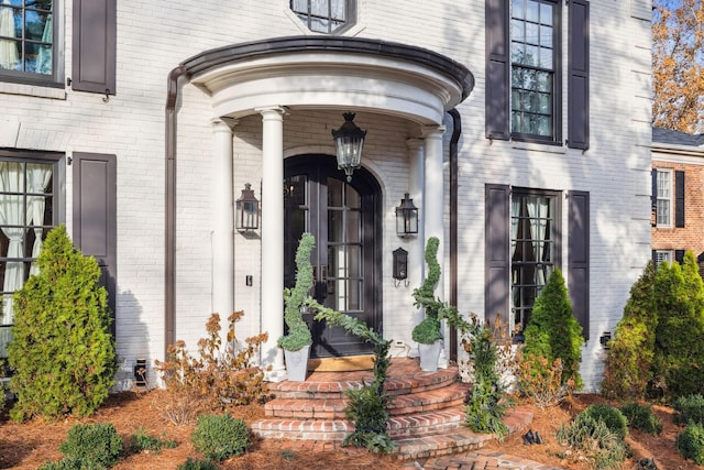 doorway to property featuring brick siding