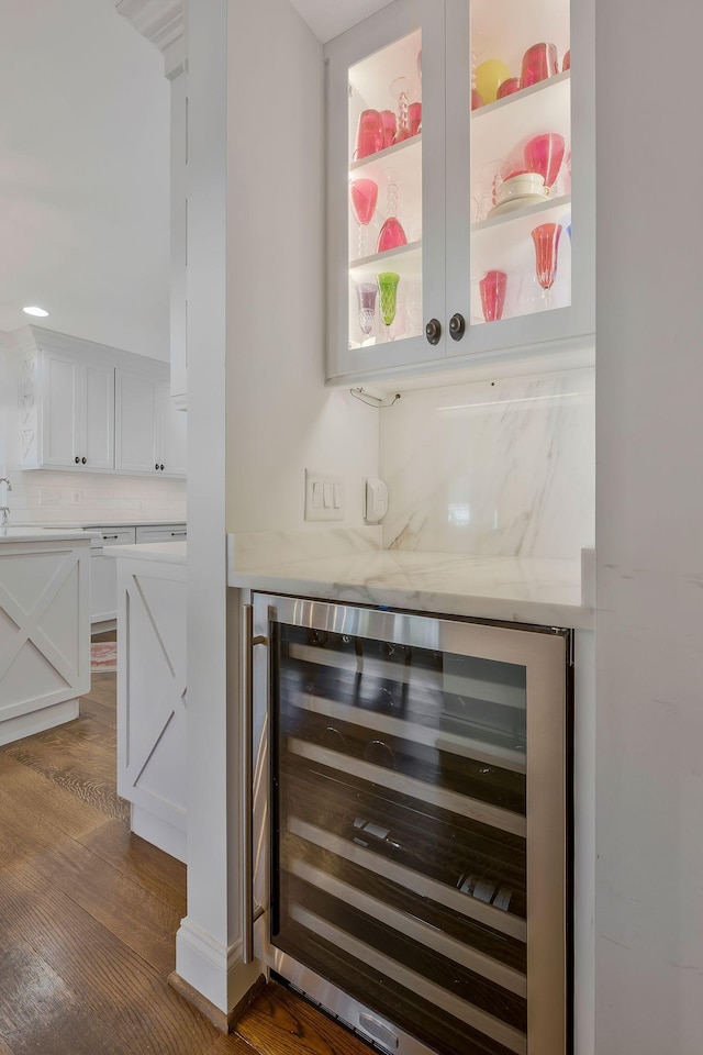 bar featuring white cabinets, decorative backsplash, dark wood-type flooring, and wine cooler