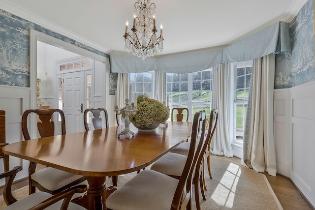 dining space with ornamental molding, hardwood / wood-style flooring, and a notable chandelier