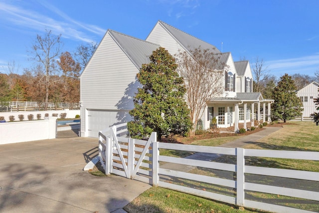 210 Green Rd, Franklin, TN 37069 - view of property exterior featuring a fenced front yard, concrete driveway, a porch, a metal roof, and a garage