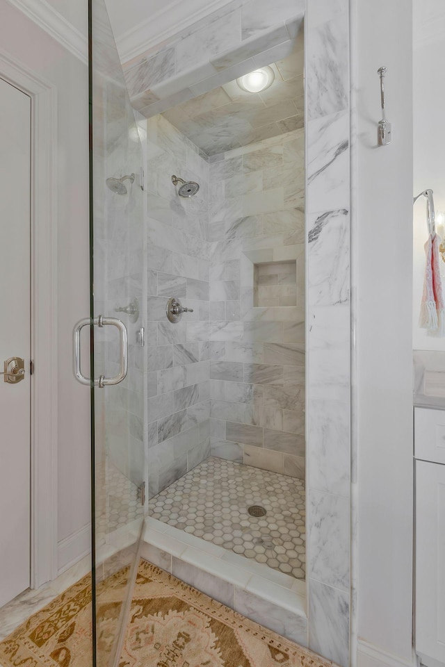 bathroom with tile patterned floors, a shower with shower door, and ornamental molding