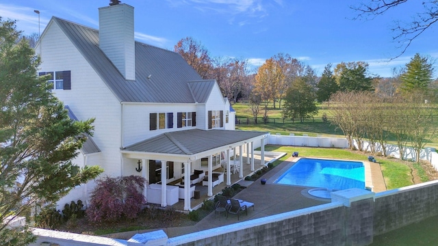 210 Green Rd, Franklin, TN 37069 - rear view of property featuring a fenced backyard, a metal roof, a patio, a chimney, and a standing seam roof