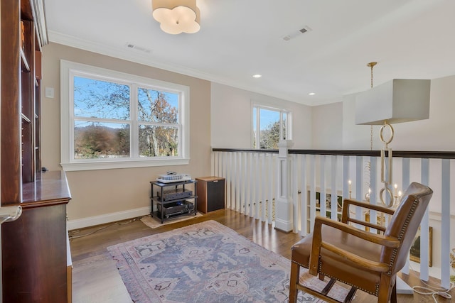 sitting room featuring hardwood / wood-style floors, an inviting chandelier, and crown molding