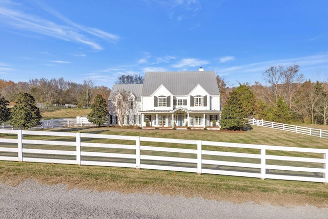 cape cod home with a front lawn and a rural view