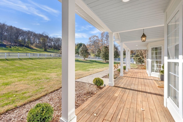 wooden deck with a yard and a rural view