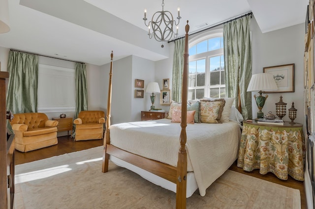 bedroom with hardwood / wood-style flooring and a chandelier