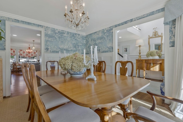 dining space featuring hardwood / wood-style floors, an inviting chandelier, and crown molding