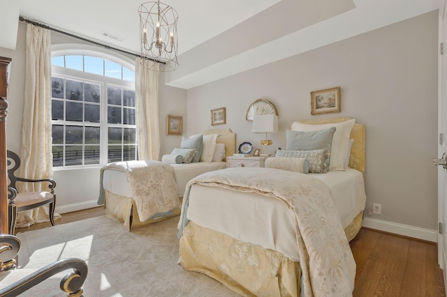 bedroom featuring light hardwood / wood-style floors and a notable chandelier