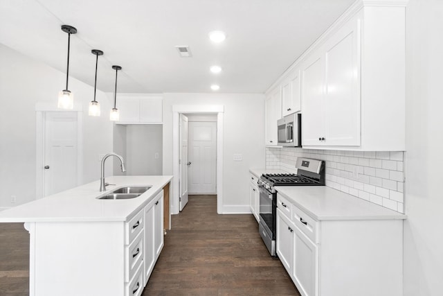 kitchen featuring a kitchen island with sink, sink, dark hardwood / wood-style floors, white cabinetry, and stainless steel appliances