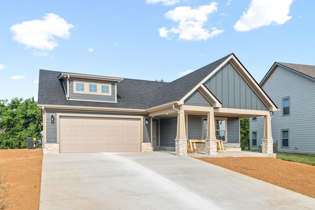 craftsman inspired home with a garage, covered porch, and central air condition unit