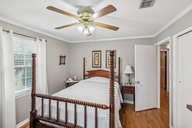 bedroom featuring ceiling fan, crown molding, and hardwood / wood-style flooring