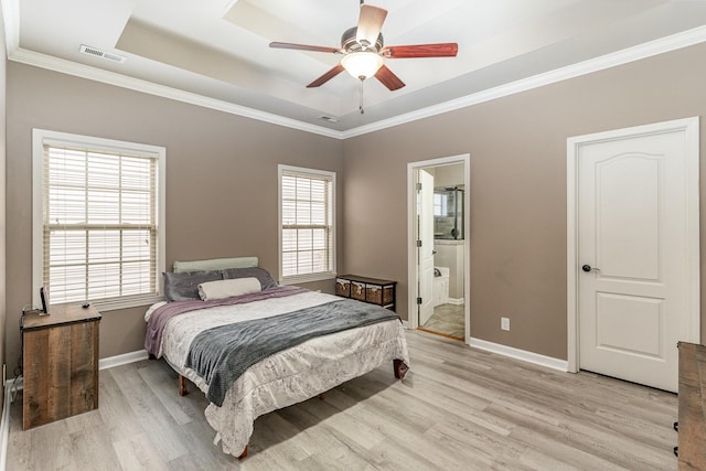 bedroom featuring multiple windows, ensuite bathroom, and light wood-type flooring