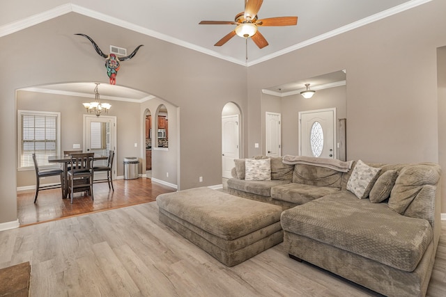 living room featuring hardwood / wood-style flooring, ceiling fan with notable chandelier, and ornamental molding