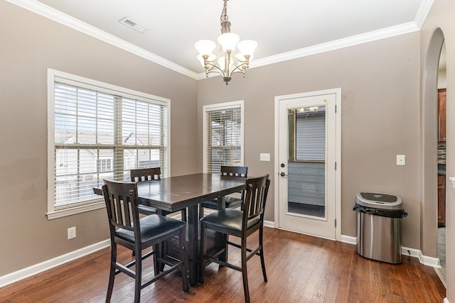 dining area featuring crown molding, dark hardwood / wood-style floors, and a notable chandelier