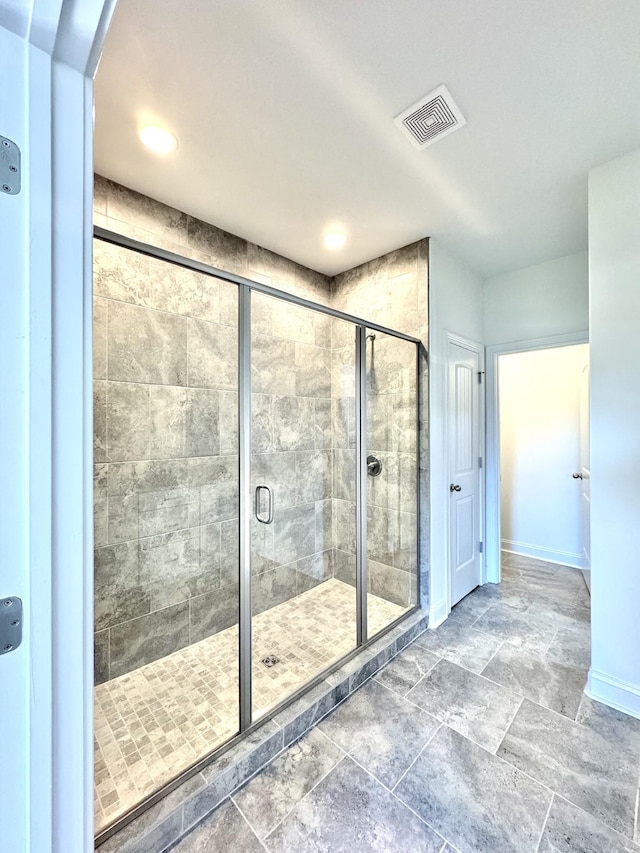 full bathroom with a stall shower, visible vents, and baseboards