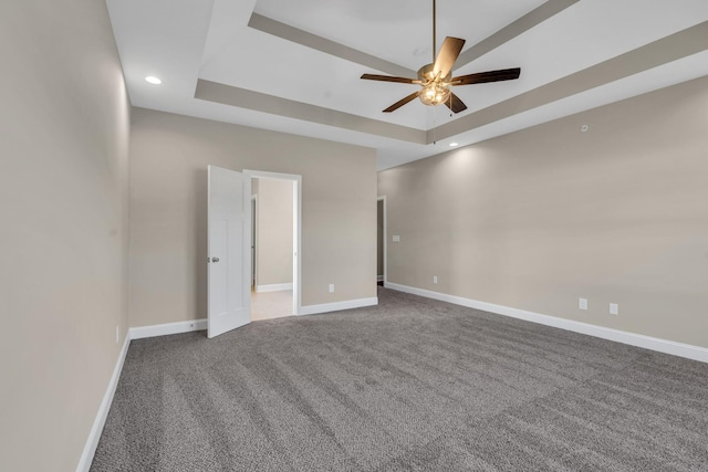 spare room with carpet floors, a raised ceiling, and ceiling fan