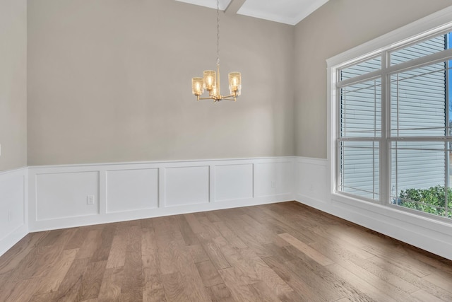 unfurnished room with a chandelier and wood-type flooring