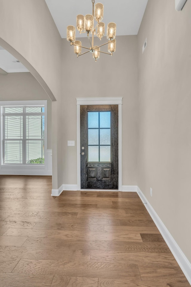 entrance foyer with wood-type flooring and an inviting chandelier