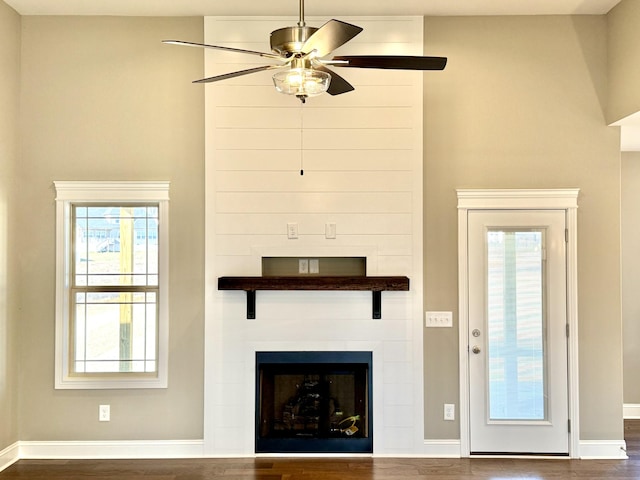 unfurnished living room with ceiling fan and dark hardwood / wood-style flooring