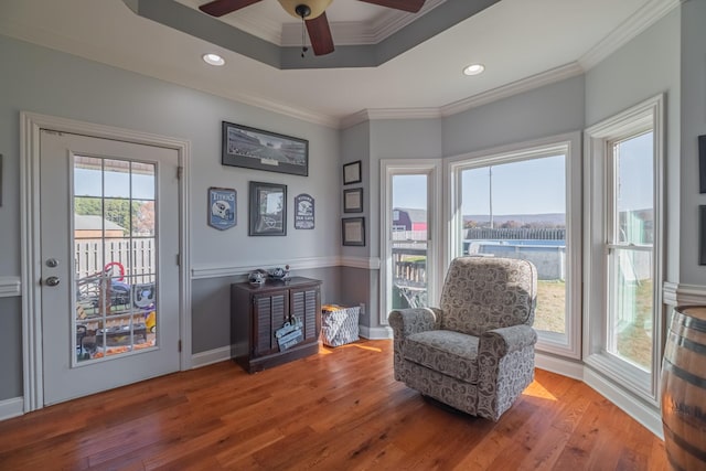 sitting room featuring hardwood / wood-style flooring, a wealth of natural light, crown molding, and ceiling fan