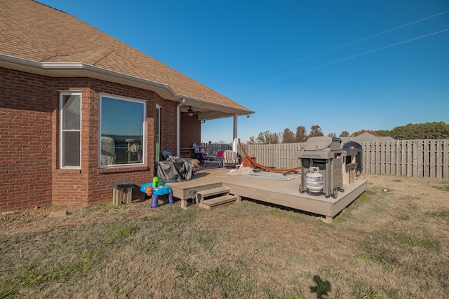 view of yard featuring ceiling fan, a deck, and a fenced backyard