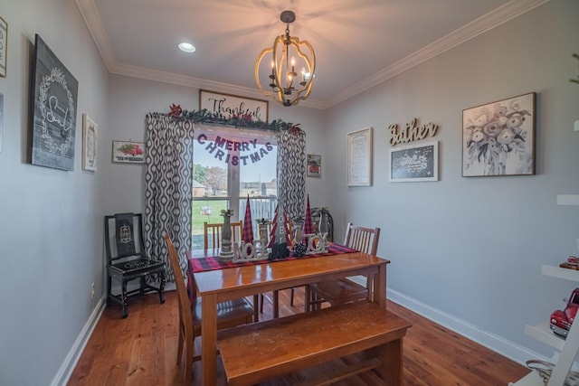 dining room featuring an inviting chandelier, crown molding, wood finished floors, and baseboards