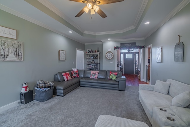 carpeted living room with recessed lighting, a raised ceiling, ornamental molding, and a ceiling fan