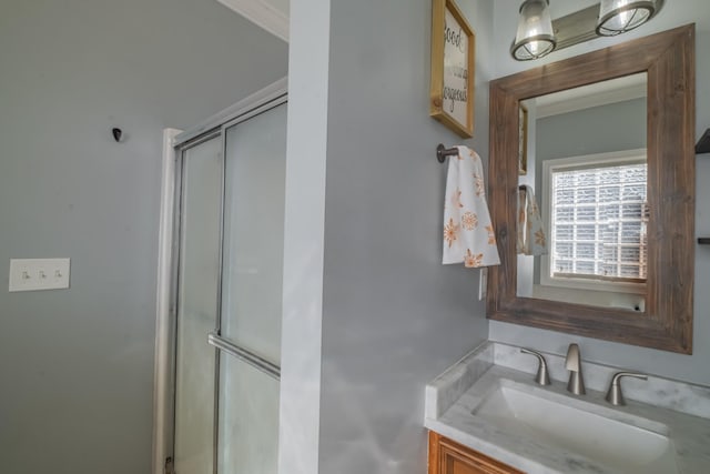 bathroom featuring vanity, crown molding, and a shower with shower door