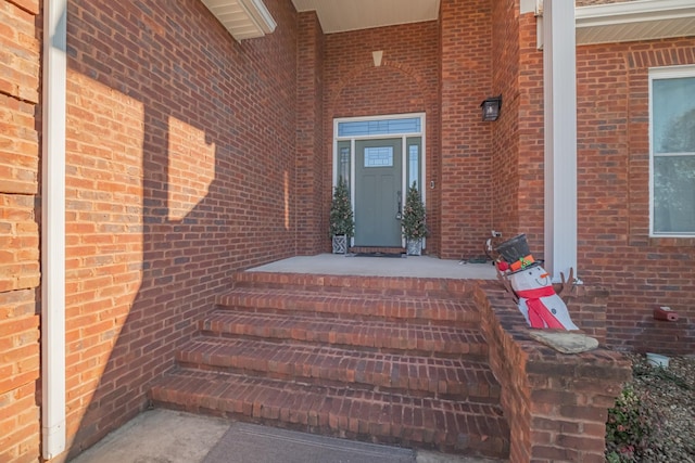 view of exterior entry with brick siding