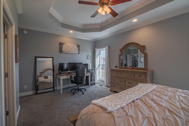 bedroom featuring a raised ceiling, ceiling fan, dark carpet, and ornamental molding