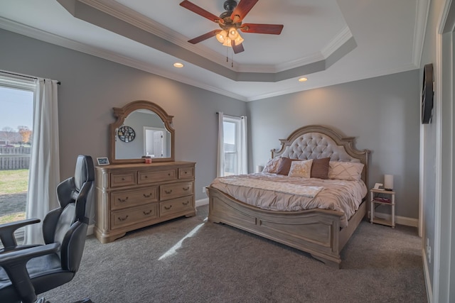 bedroom with dark colored carpet, a raised ceiling, ceiling fan, and crown molding