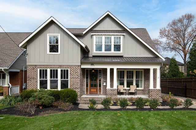 rear view of house with a lawn and covered porch