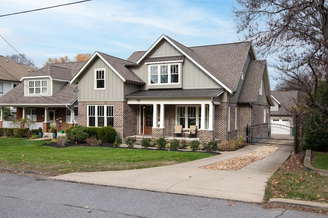 view of front of property with covered porch, a garage, and a front yard