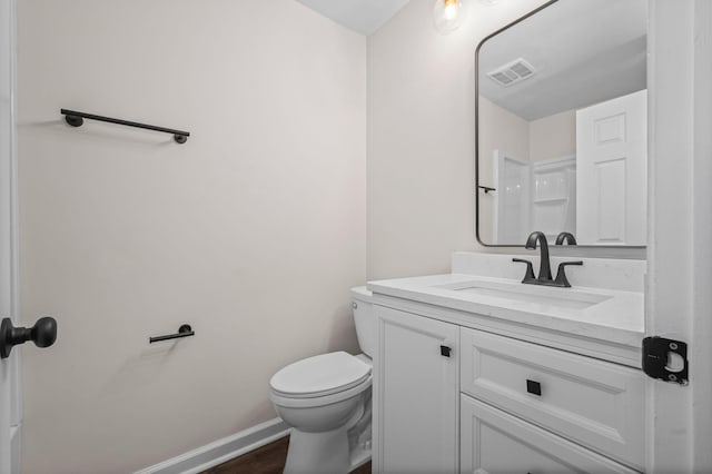 bathroom with vanity, hardwood / wood-style floors, and toilet