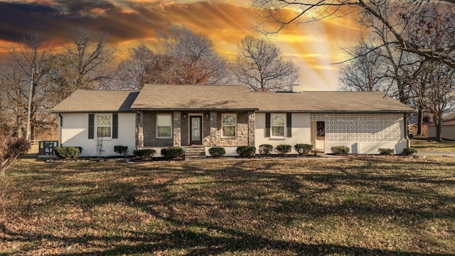 ranch-style house featuring stone siding, brick siding, and a front yard