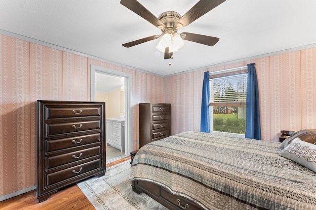 bedroom featuring ensuite bath, light hardwood / wood-style floors, and ceiling fan