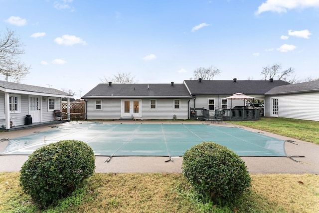 view of pool with a yard, a patio, and french doors