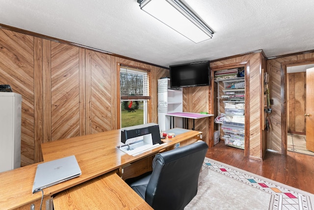 home office featuring wooden walls and a textured ceiling