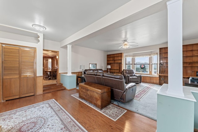 living room with ceiling fan, decorative columns, and light wood-type flooring