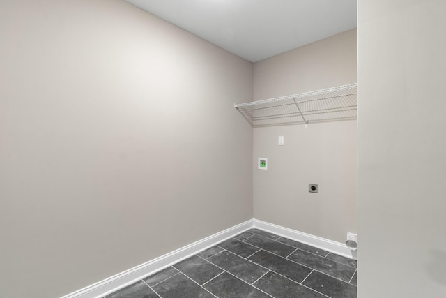 laundry room with electric dryer hookup and dark tile patterned floors