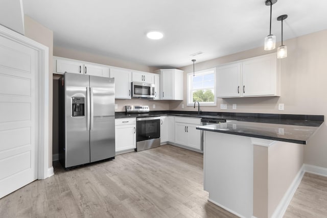 kitchen with a peninsula, white cabinetry, light wood-style floors, hanging light fixtures, and appliances with stainless steel finishes