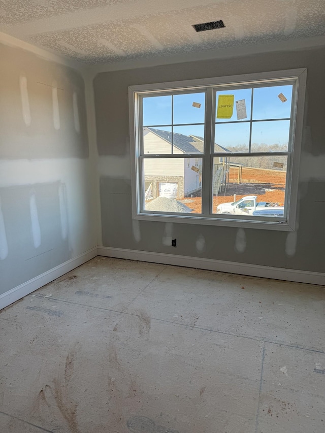 unfurnished room with a healthy amount of sunlight and a textured ceiling