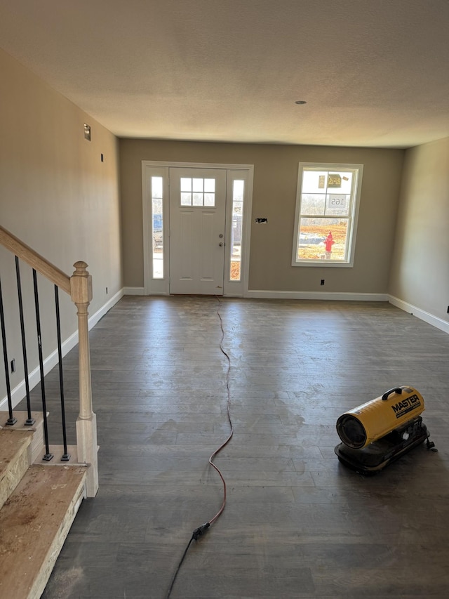 foyer entrance with baseboards, stairway, and wood finished floors