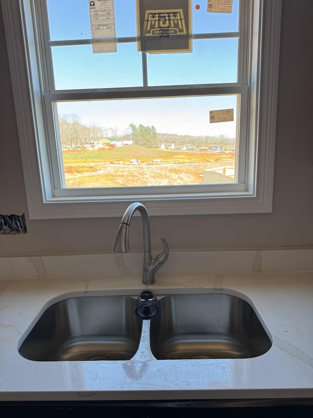 room details featuring a sink and light stone countertops