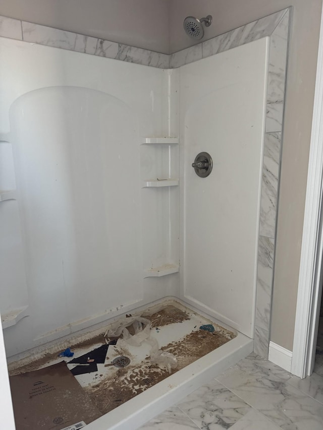 full bathroom with a shower and marble finish floor