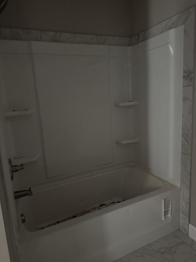 bathroom featuring marble finish floor and  shower combination