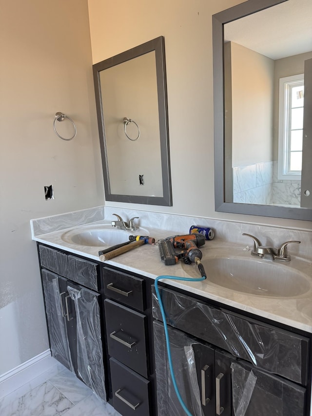 bathroom with marble finish floor and vanity