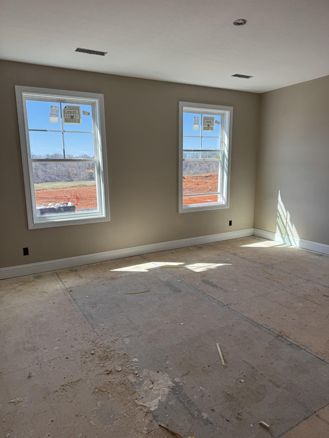 unfurnished room with visible vents and baseboards