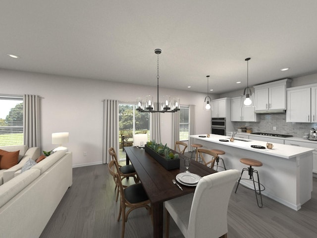 dining space with a healthy amount of sunlight, sink, dark wood-type flooring, and an inviting chandelier