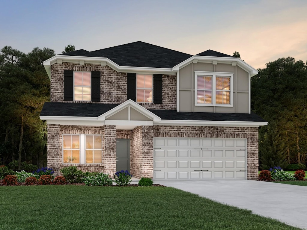 view of front facade with a yard and a garage